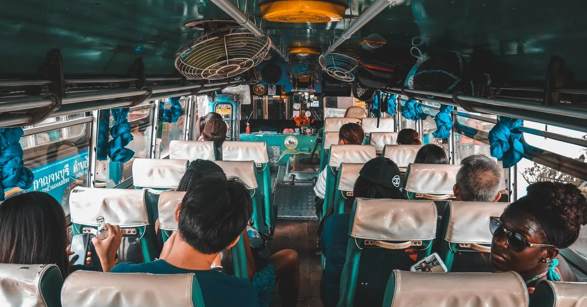 Un groupe diversifié de touristes voyageant en bus à Kanchanaburi, Thaïlande.