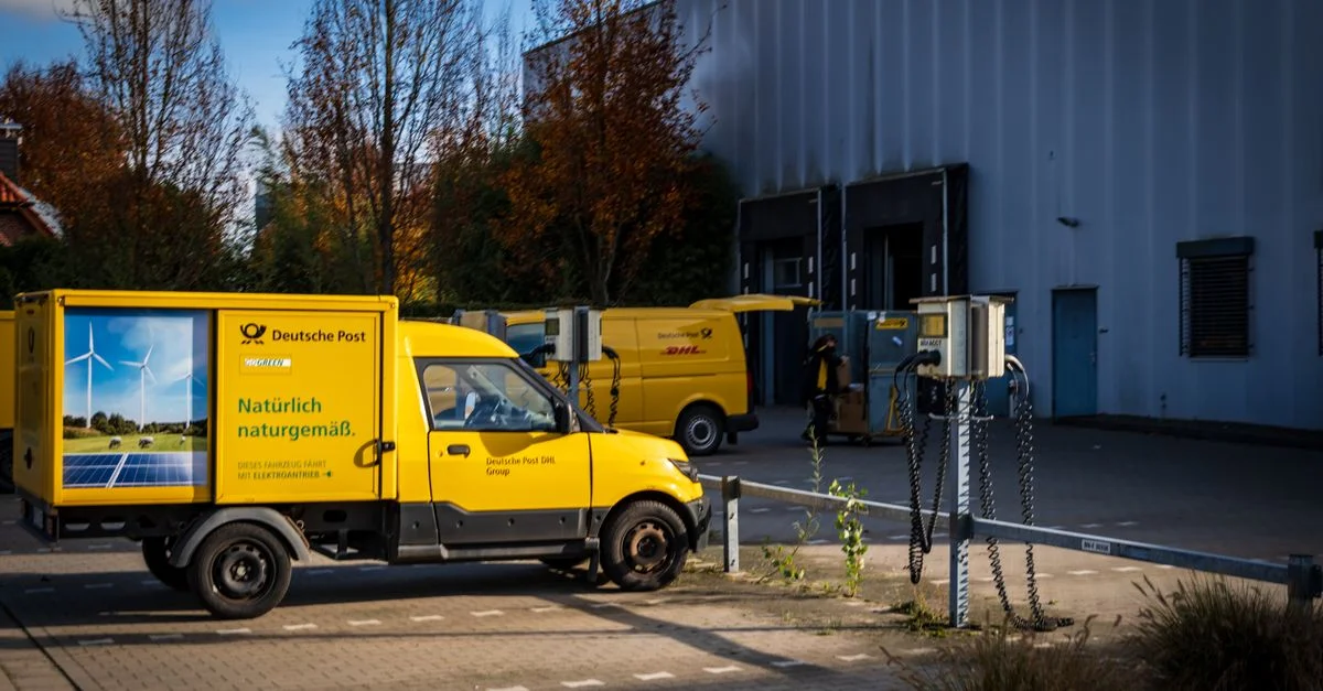 Des fourgonnettes de livraison électriques de la Deutsche Post stationnées à l'extérieur, illustrant une logistique durable.