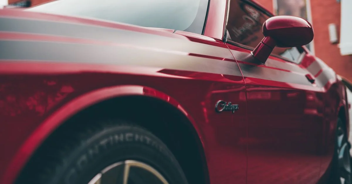 Vue détaillée d'une voiture de sport rouge polie mettant en avant son design élégant et sa finition moderne.