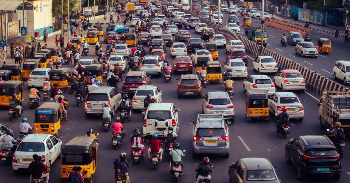 Une rue de ville bondée remplie de voitures, de motos et de bus pendant l'heure de pointe de la journée.