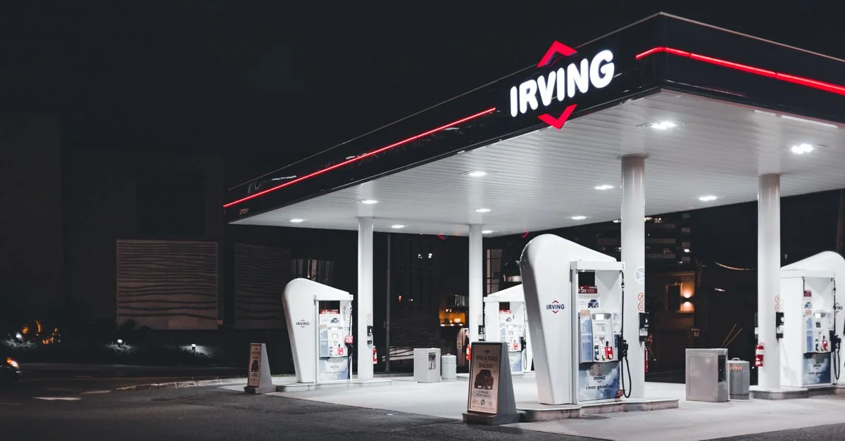 Station-service Irving illuminée la nuit, mettant en avant un design moderne et un éclairage lumineux.