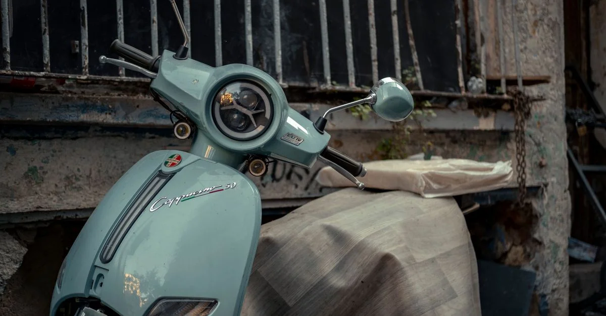 Stylé scooter bleu vintage garé dans un environnement urbain, évoquant une ambiance nostalgique de rue citadine.