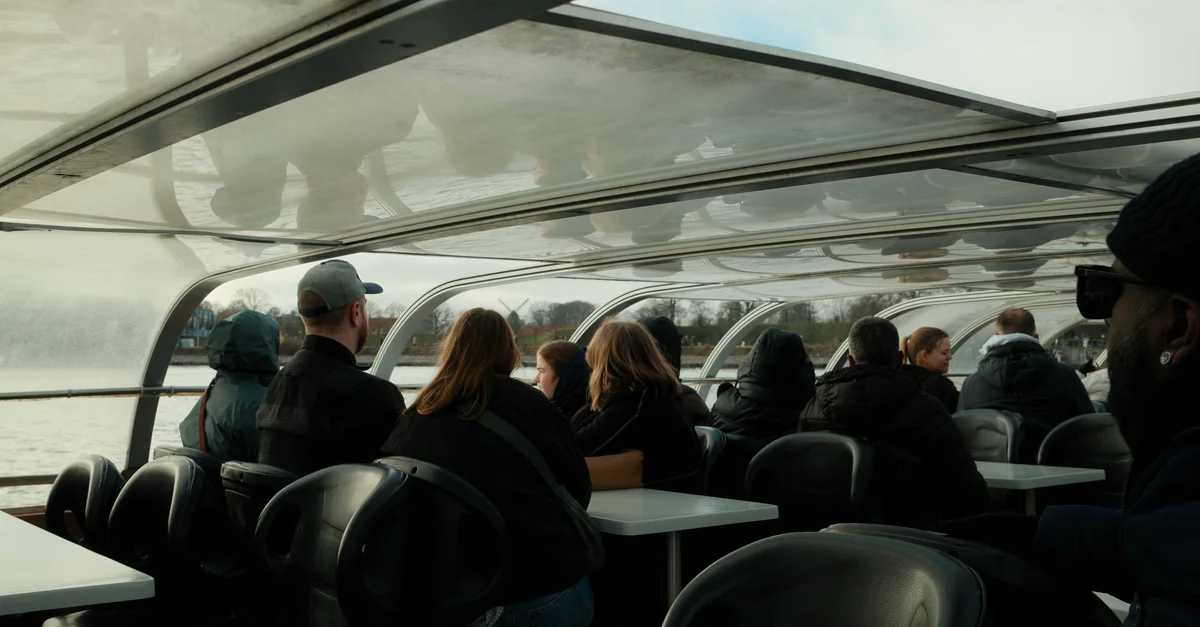 Les passagers profitent d'une vue panoramique depuis un bateau fluvial vitré. Idéal pour les photos de tourisme et de voyage.